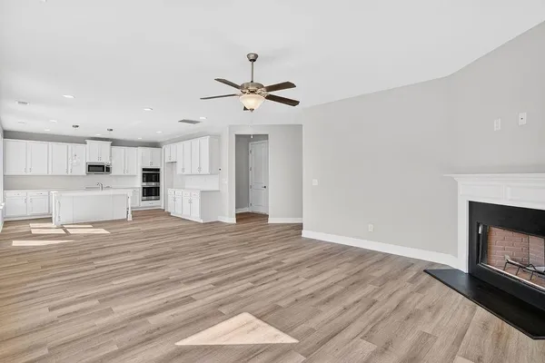 a view of empty room with wooden floor and fireplace