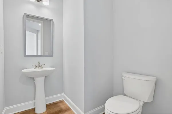 a bathroom with a toilet a sink and mirror
