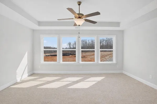 an empty room with a window and a ceiling fan