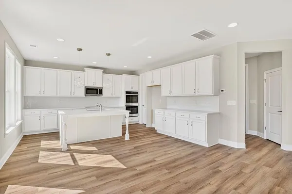 a view of kitchen with wooden floor and electronic appliances