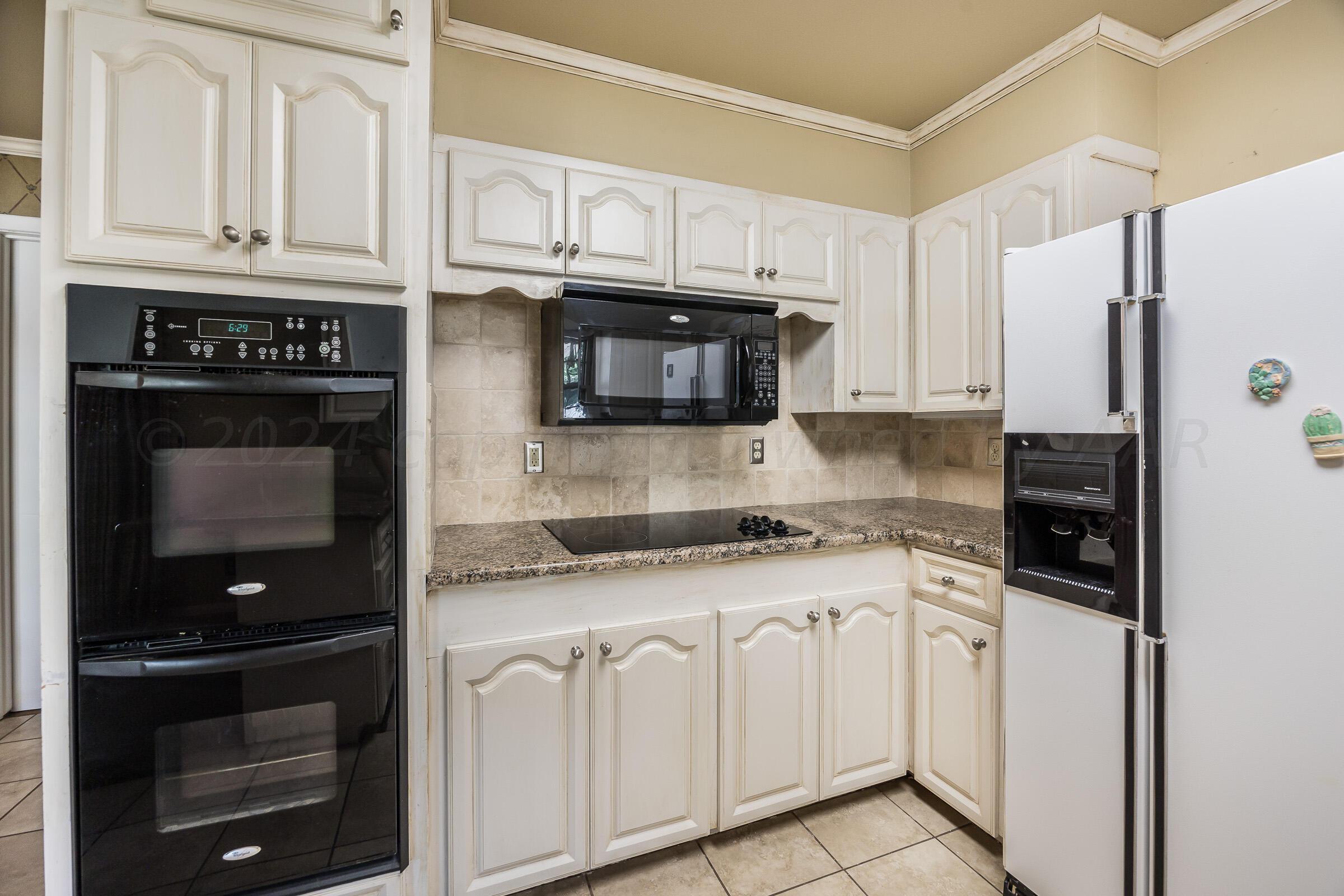 5502 Brinkman Drive Amarillo, TX 79106 - Photo 11 of 22 a kitchen with granite countertop white cabinets and stainless steel appliances