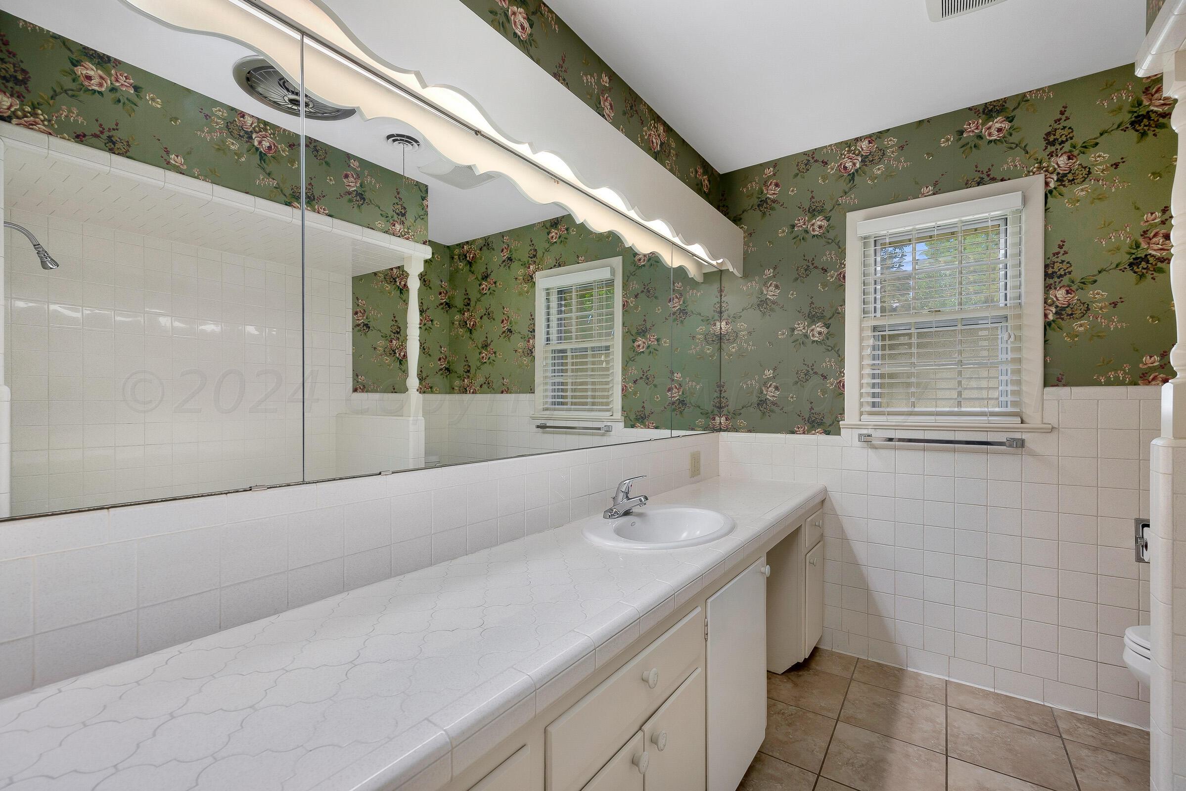 5502 Brinkman Drive Amarillo, TX 79106 - Photo 16 of 22 a bathroom with a sink a toilet and shower