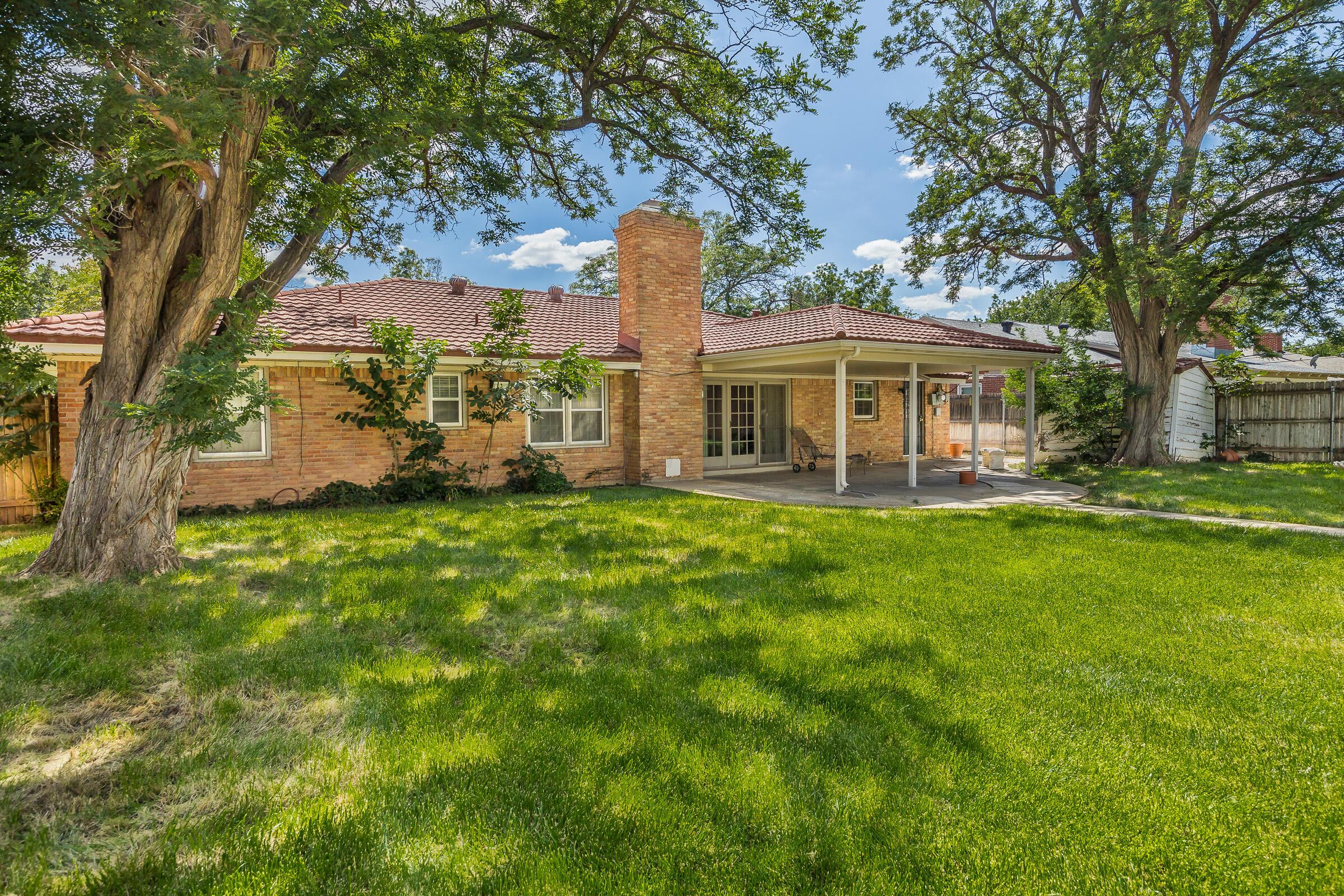 5502 Brinkman Drive Amarillo, TX 79106 - Photo 19 of 22 a front view of a house with a garden and trees