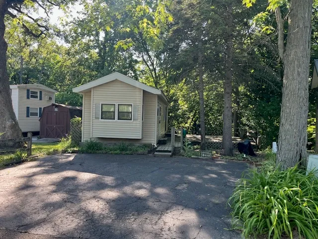 a view of a small house with a tree in the background