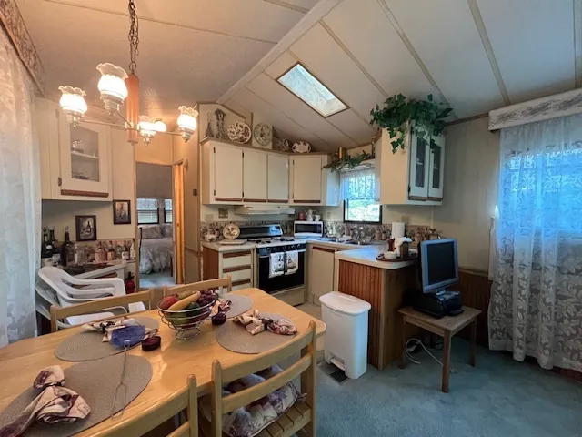 a kitchen with kitchen island a stove and a chandelier