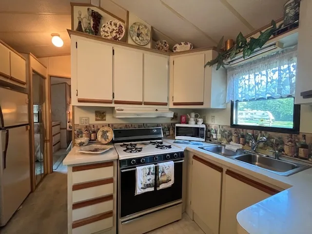 a kitchen with stainless steel appliances a stove a sink and a refrigerator