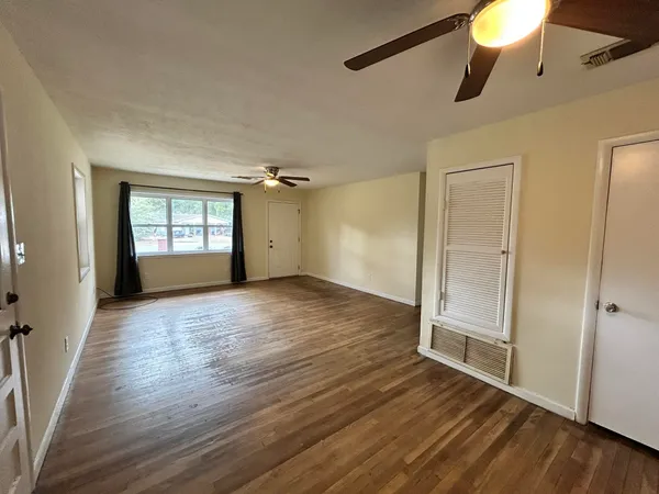 wooden floor in an empty room with a window