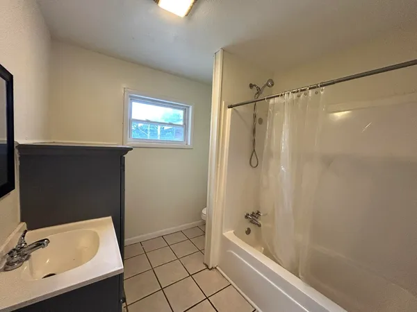 a bathroom with a tub a sink and mirror