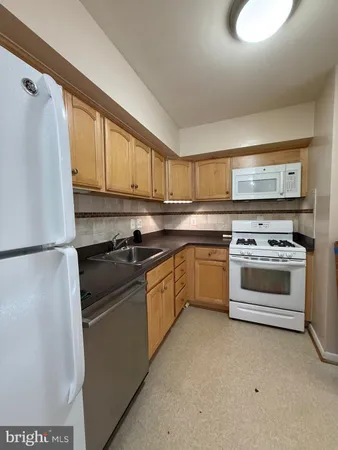 a kitchen with a stove top oven sink and refrigerator