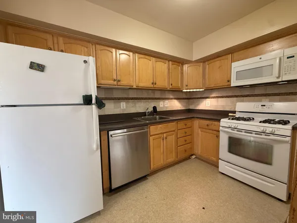 a kitchen with cabinets and white stainless steel appliances