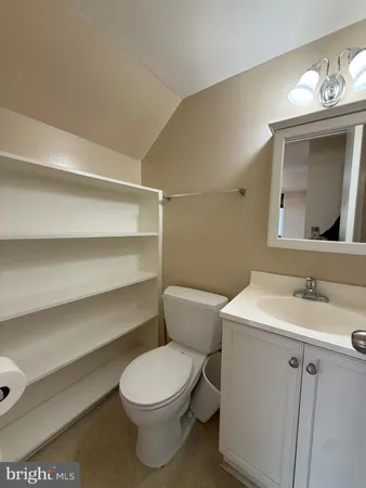 a bathroom with a toilet a sink and mirror