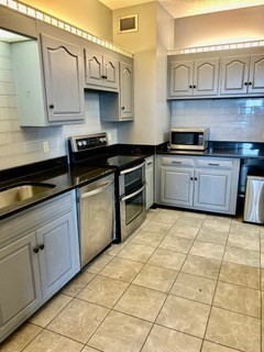 40 Village Road, Unit 1704 (PH4) Middleton, MA 01949 - Photo 10 of 35 a kitchen with stainless steel appliances granite countertop a stove a sink and a microwave