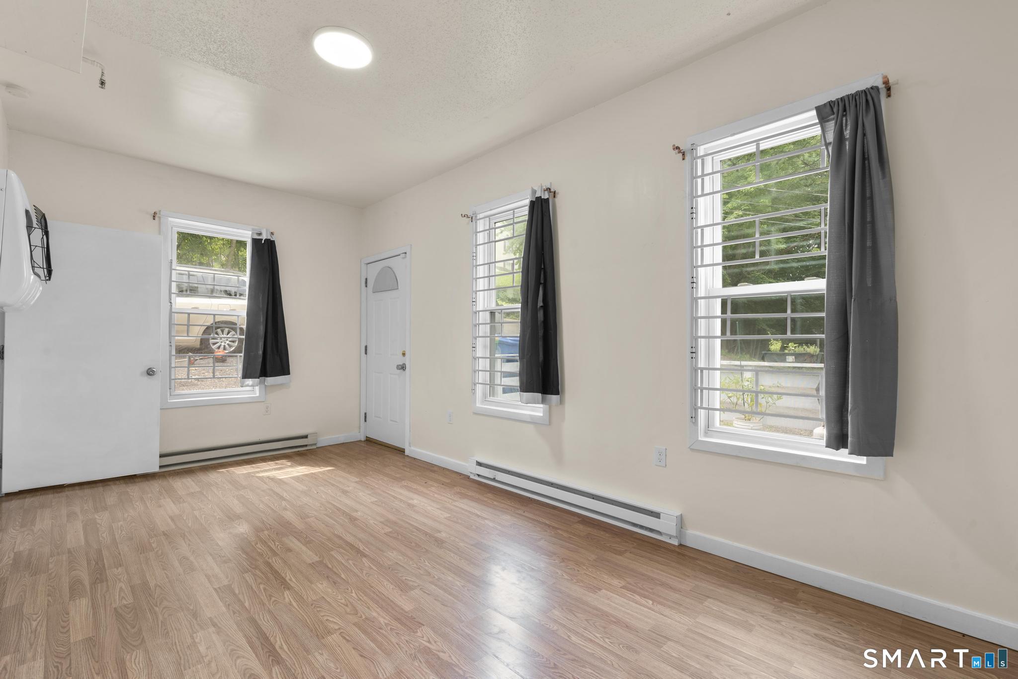 170 Meriden Road Waterbury, CT 06705 - Photo 16 of 26 a view of an empty room with wooden floor and a window