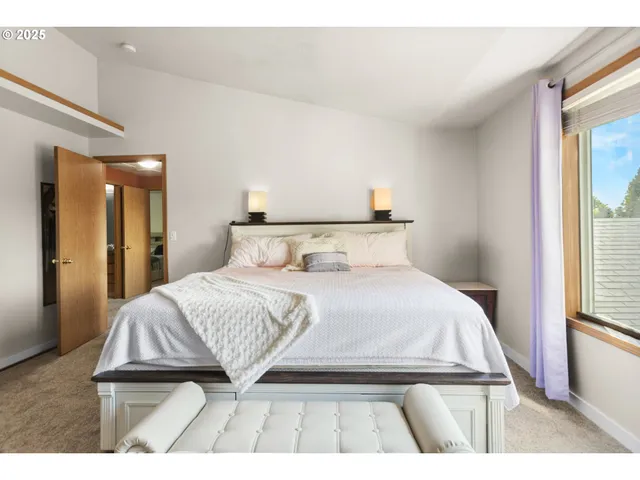 a spacious bedroom with a bed window and dresser