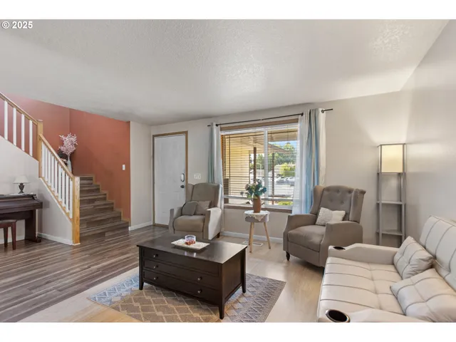 a living room with furniture rug and wooden floor