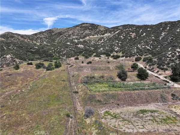 a view of a dry yard with mountains in the background