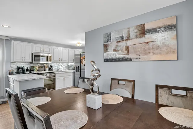 a kitchen with a table chairs stove and white cabinets