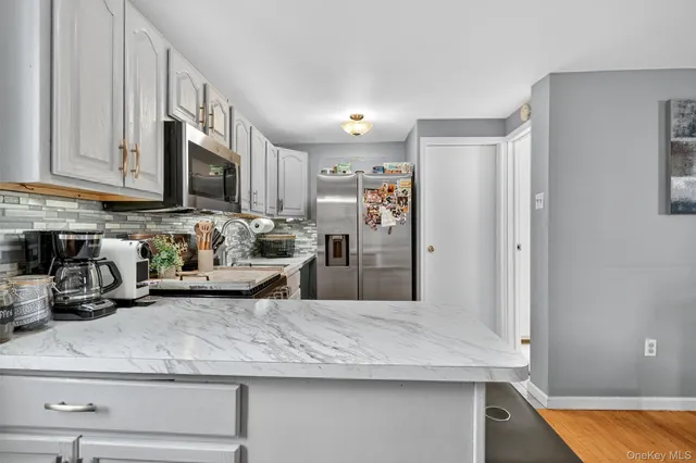 a kitchen with stainless steel appliances granite countertop a refrigerator a stove and a sink