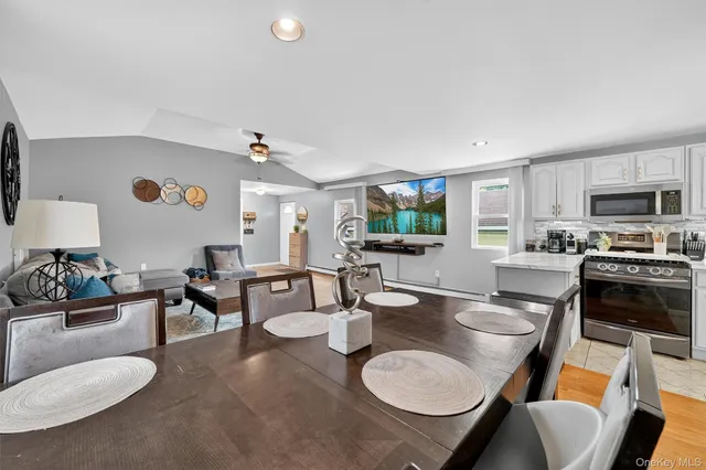 a kitchen with a table chairs stove and white cabinets