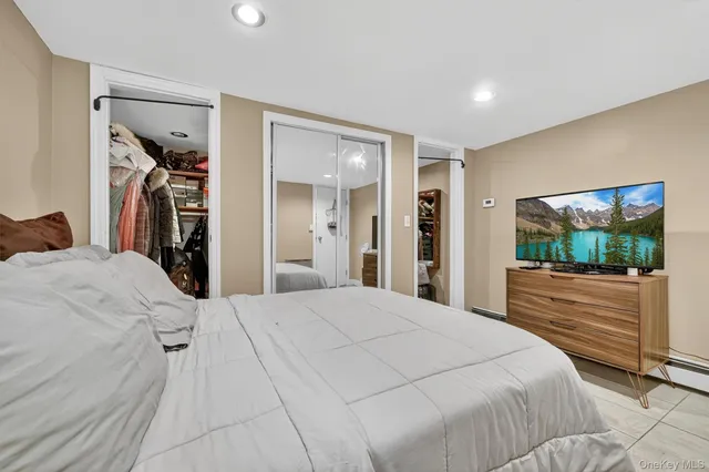 a bedroom with a large bed and a flat screen tv