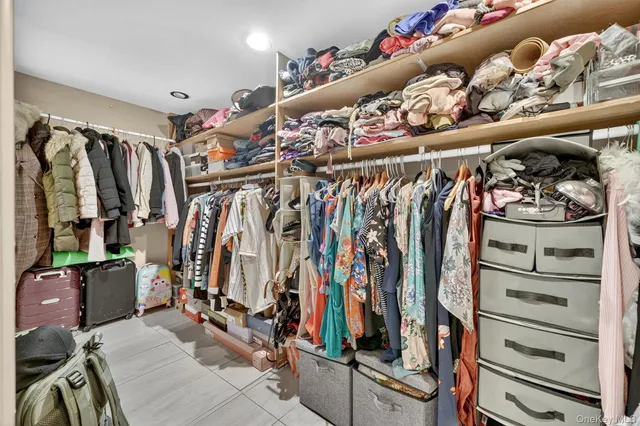 a view of walk in closet with clothes and shoes
