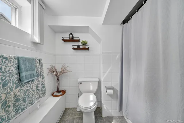 a white toilet sitting next to a shower curtain