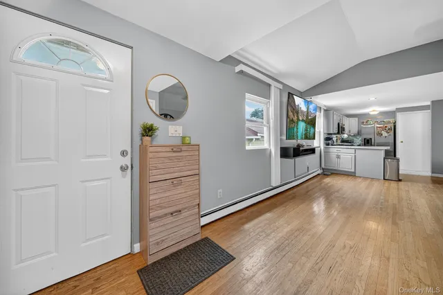 a view of a hallway with wooden floor windows and a kitchen