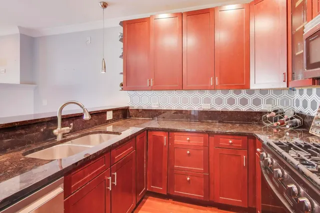 a kitchen with stainless steel appliances granite countertop a stove and a microwave