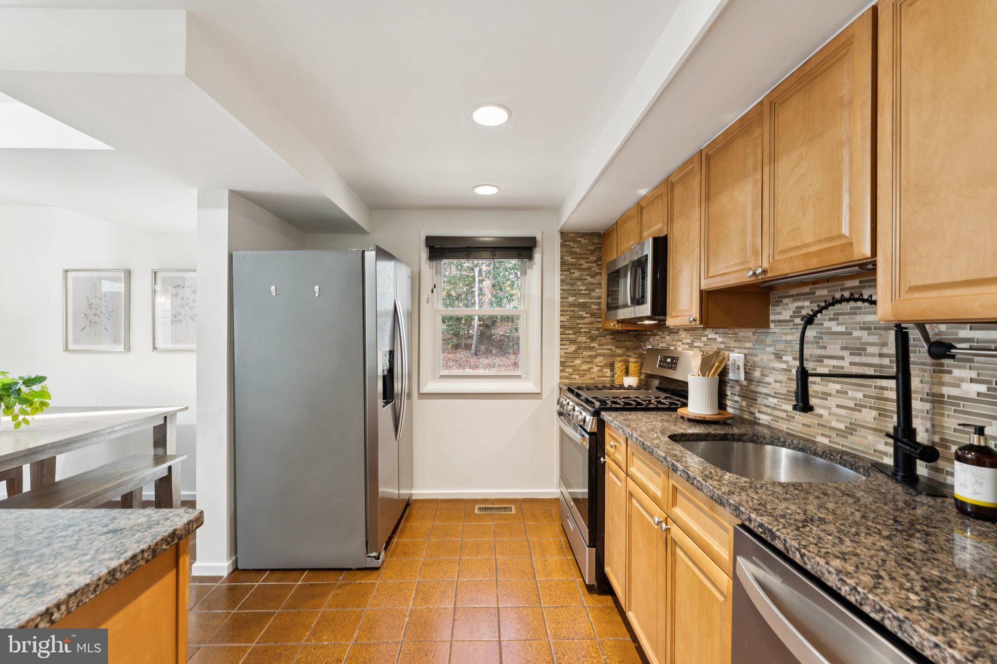 11234 Hunting Horn Lane Reston, VA 20191 - Photo 11 of 44 a kitchen with stainless steel appliances granite countertop a sink stove and refrigerator