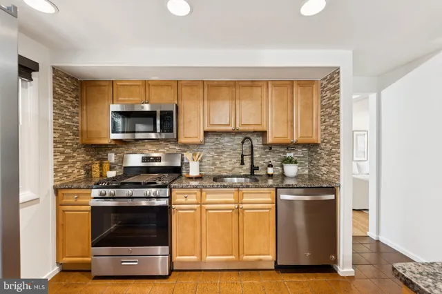 a kitchen with kitchen island granite countertop a stove and a microwave