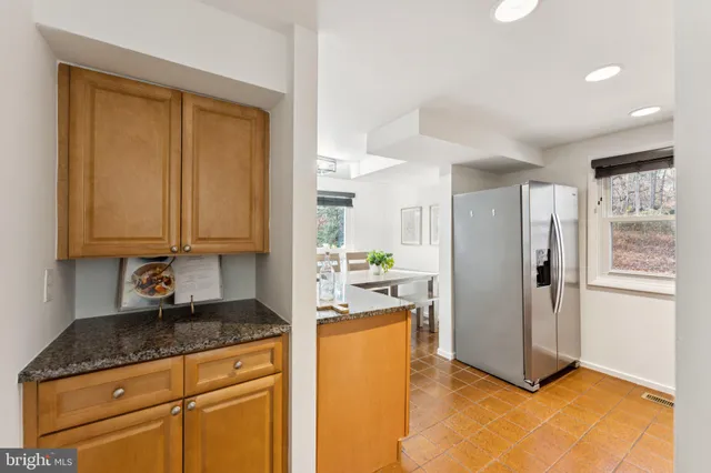 a kitchen with granite countertop cabinets and refrigerator