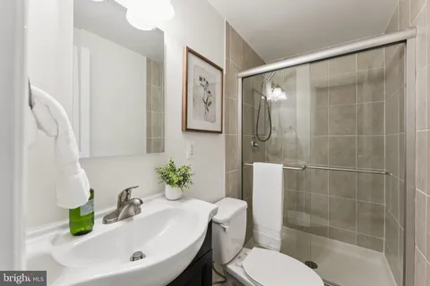 an empty room with chandelier fan and windows