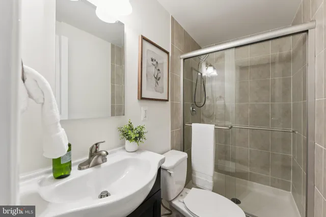 an empty room with chandelier fan and windows