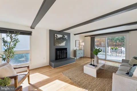 a living room with furniture large window and fireplace