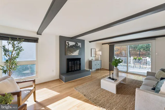 a living room with furniture large window and fireplace