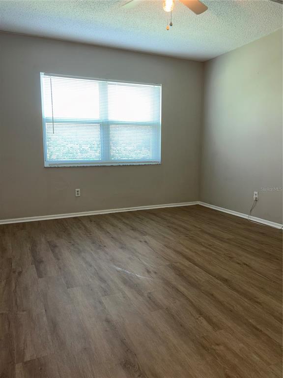 26485 Rampart Boulevard, Unit D1 Punta Gorda, FL 33983 - Photo 14 of 29 an empty room with wooden floor and windows