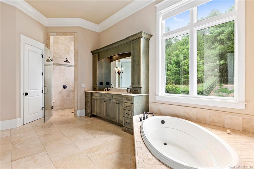 10900 Unity Church Road Mooresville, NC 28115 - Photo 17 of 31 a bathroom with a tub a sink a mirror and a shower