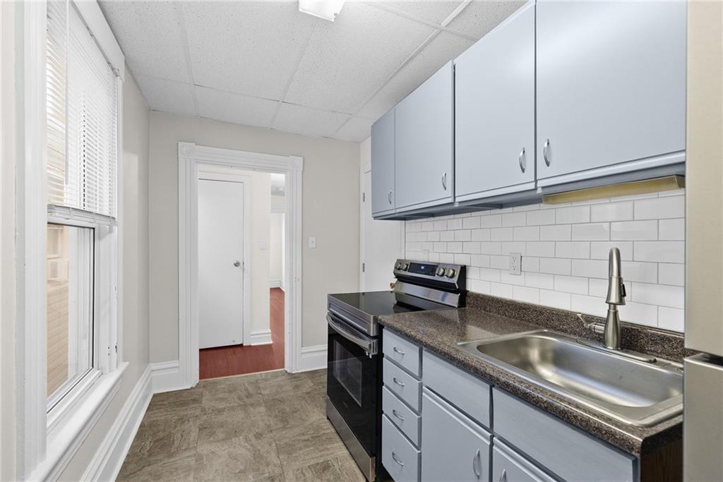 107 Dickman Street Carnegie, PA 15106 - Photo 13 of 47 a kitchen with stainless steel appliances granite countertop a sink stove and cabinets