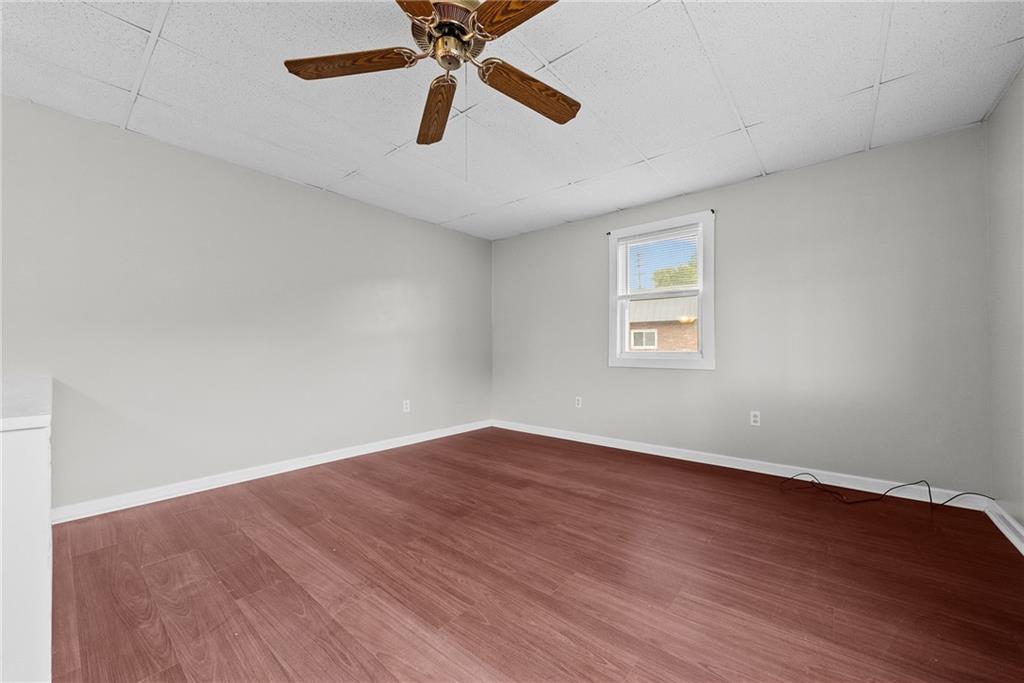 107 Dickman Street Carnegie, PA 15106 - Photo 9 of 47 an empty room with wooden floor ceiling fan and windows
