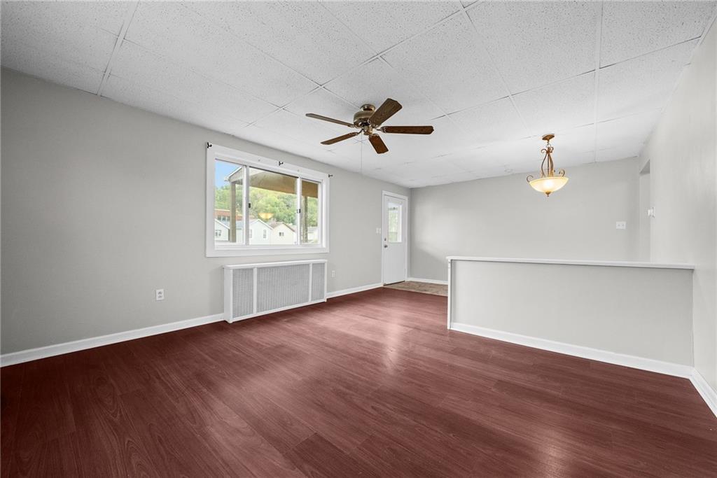 107 Dickman Street Carnegie, PA 15106 - Photo 10 of 47 an empty room with wooden floor ceiling fan and windows