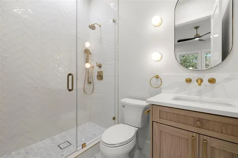 a large white kitchen with large windows and a refrigerator