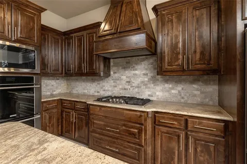 a kitchen with granite countertop cabinets stainless steel appliances and a counter space