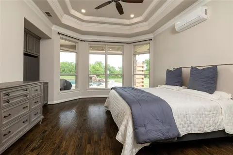 a bedroom with a large bed and a flat tv screen on dresser