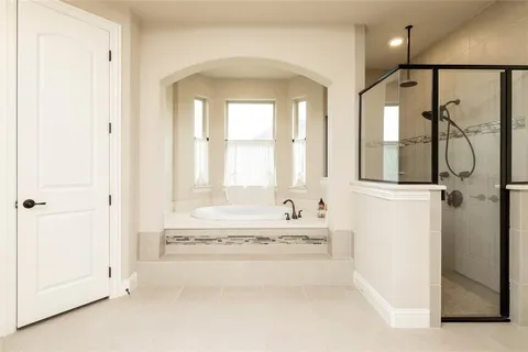 a spacious bathroom with a tub and a shower