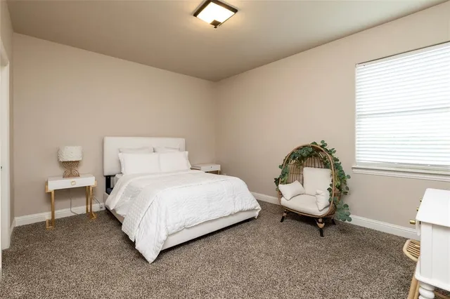 a bedroom with a bed a table and window