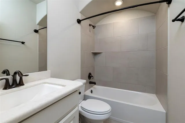 a bathroom with a bathtub shower sink vanity and toilet