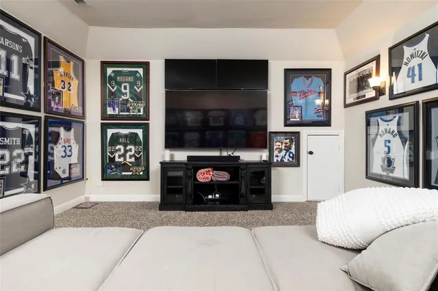 a living room with stainless steel appliances furniture a fireplace and a flat screen tv