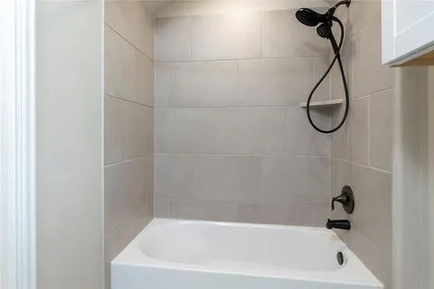a bathroom with a bath tub with a shower