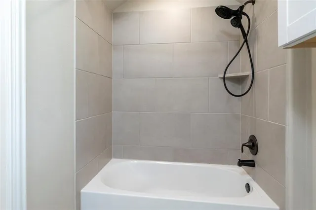 a bathroom with a bath tub with a shower