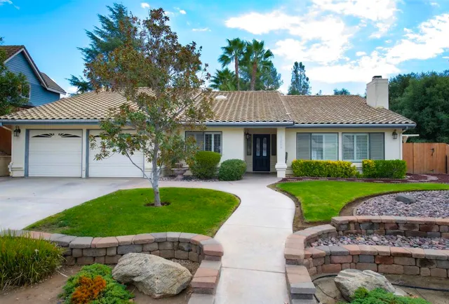 a house with green field in front of it